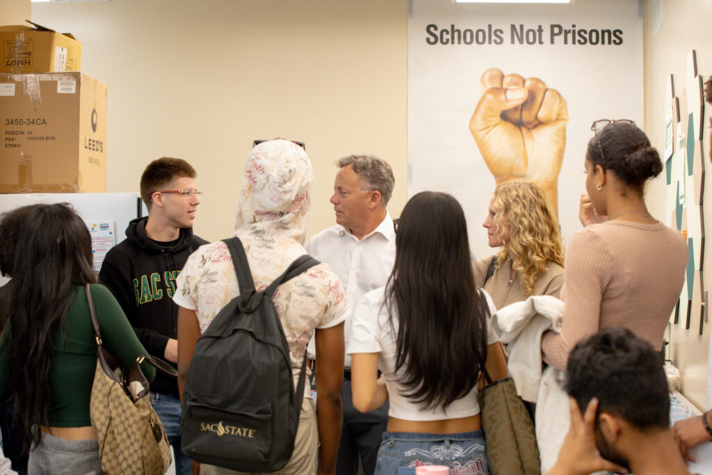 Students talking in a group with a professor